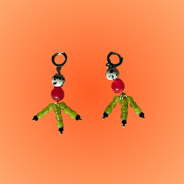 Pair of earrings with cartoon character figures on an orange gradient background