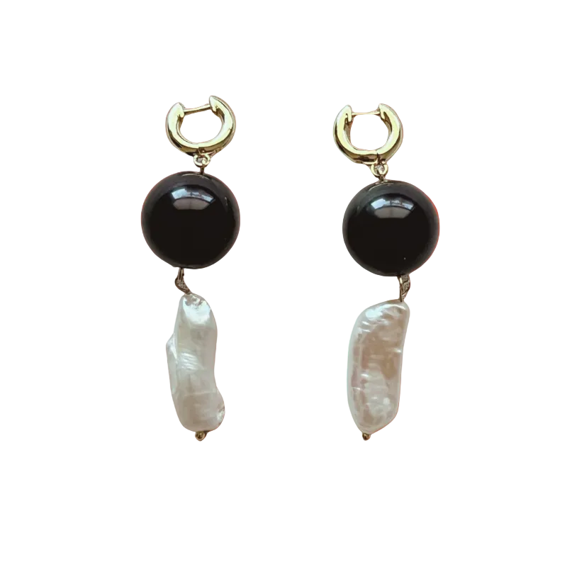 Pair of earrings with black and white stones on a gradient background