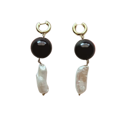 Pair of earrings with black and white stones on a gradient background