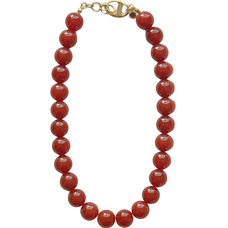 Red beaded necklace with a gold clasp on an orange gradient background