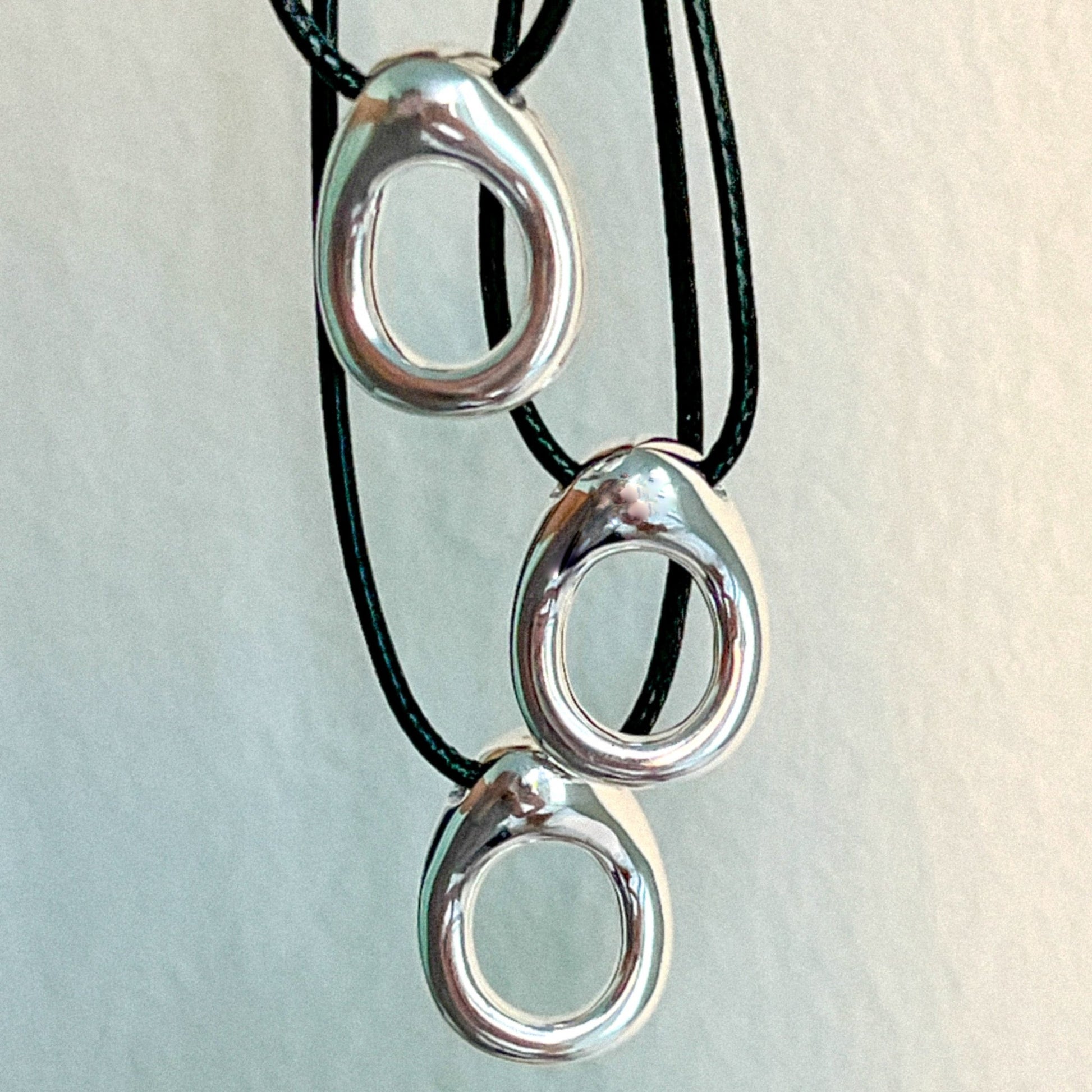 Image of 3 Simple circular leather necklace with a small organically shaped circular sterling silver pendant.